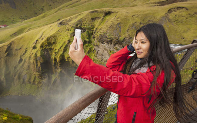 Bela mulher tomando selfie em Skogarfoss cachoeira na Islândia — Fotografia de Stock
