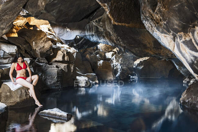 Frau sitzt in Grjotgja-Höhle im Norden Islands — Stockfoto