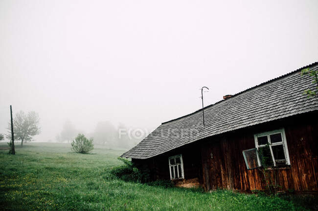 Velha casa vintage em montanhas no dia de nevoeiro — Fotografia de Stock