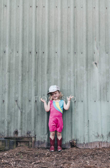 Молода дівчина стоїть біля сараю, одягнена в летар і черевики для павуків . — стокове фото