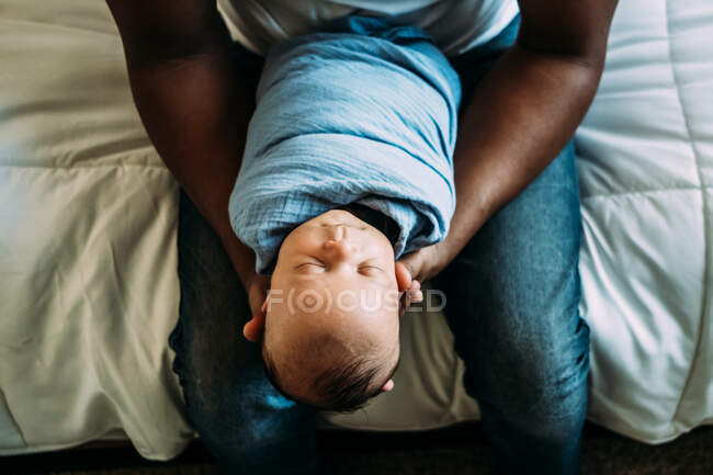 Overhead portrait of sleeping baby in dads arms — Stock Photo