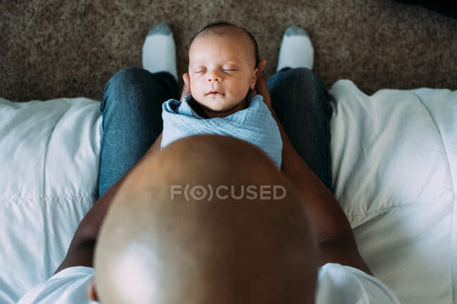Bebê recém-nascido dormindo nos braços pais — Fotografia de Stock