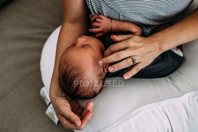Overhead of newborn baby napping in mothers arms — Stock Photo
