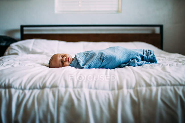 Центральный портрет новорожденного, спящего на кровати — стоковое фото