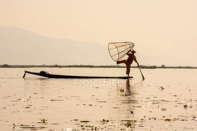 Local man balancing himself on the boat — Stock Photo