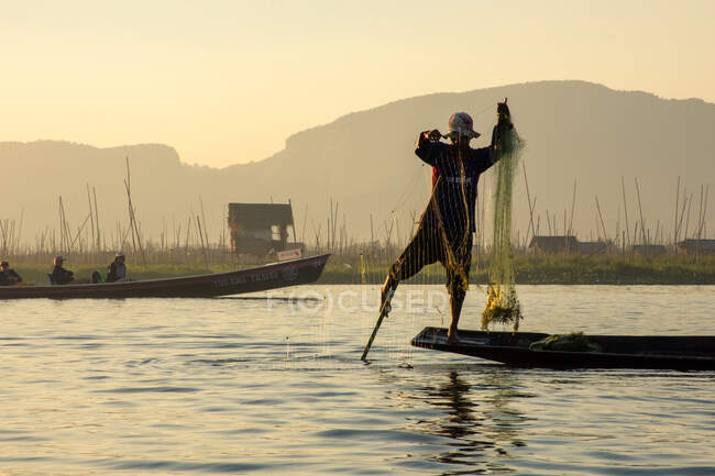 Fishing during sunset time in the lake — Stock Photo