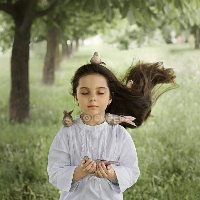 Ein Mädchen mit gegelten Haaren und Vögeln, die auf ihr und in ihrem Haar sitzen — Stockfoto