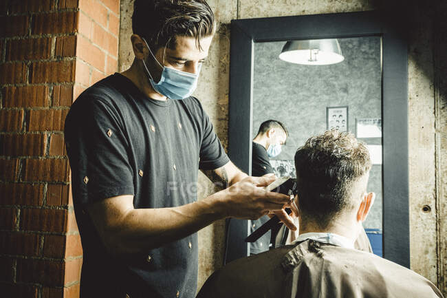 Esteticista y peluquero trabajando con máscara para el virus covid19 - foto de stock