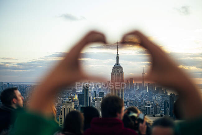 La gente guarda dai grattacieli gli edifici di New York al tramonto e scatta foto con il cellulare, Stati Uniti — Foto stock