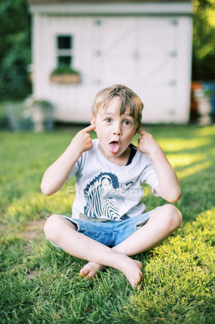 Retrato de un lindo bobo de cinco años haciendo caras tontas - foto de stock