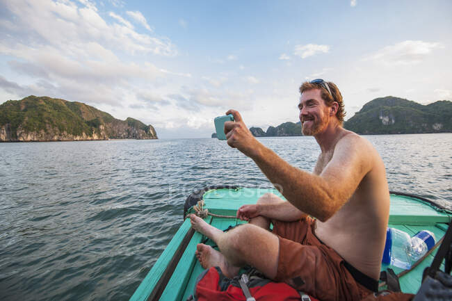 Мужчина делает селфи на лодке в заливе Халонг во Вьетнаме — стоковое фото