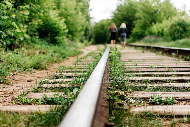Meninas andam juntas por ferrovia — Fotografia de Stock