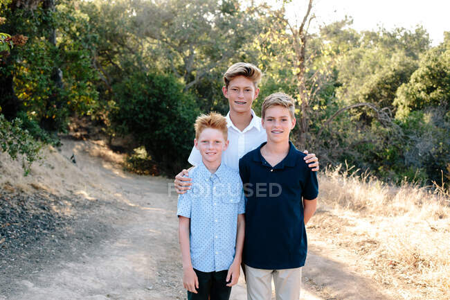 Retrato de tres chicos guapos en una ruta de senderismo - foto de stock