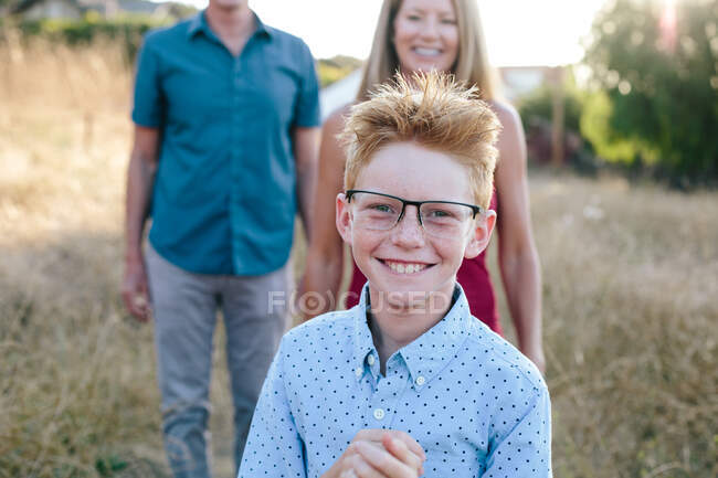 Red Haired Boy sonríe mientras usa gafas de gran tamaño - foto de stock