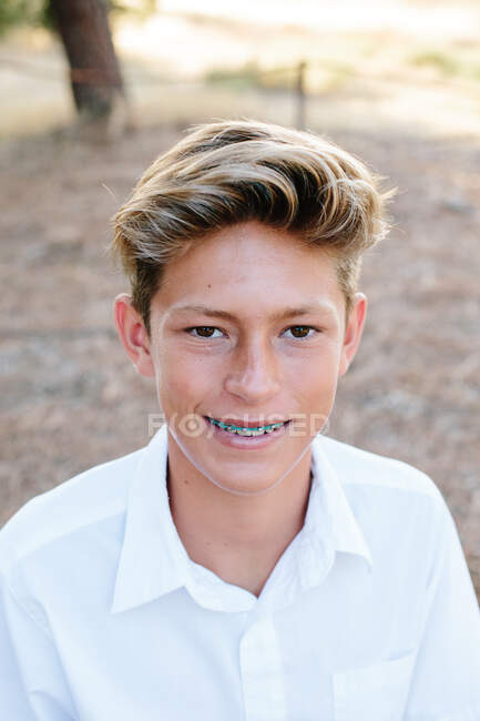 Портрет красивого мальчика-подростка с карими глазами и брекетами — стоковое фото