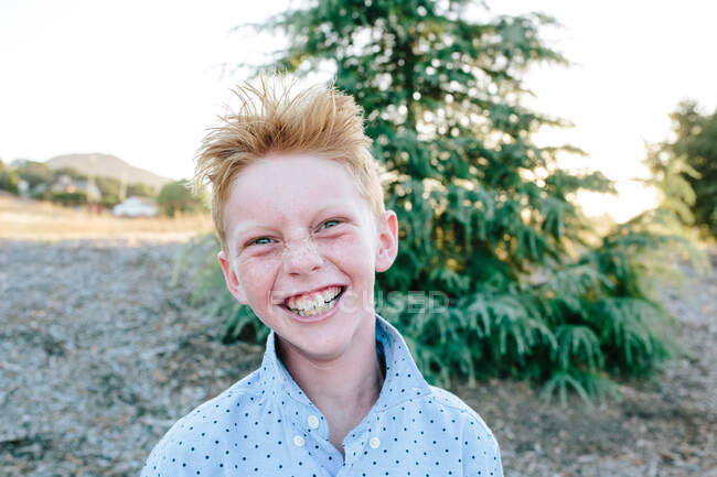 Um menino de cabeça vermelha com sardas sorrindo um sorriso louco — Fotografia de Stock