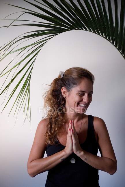 Жінка робить йогу позу вдома з білим тлом — стокове фото