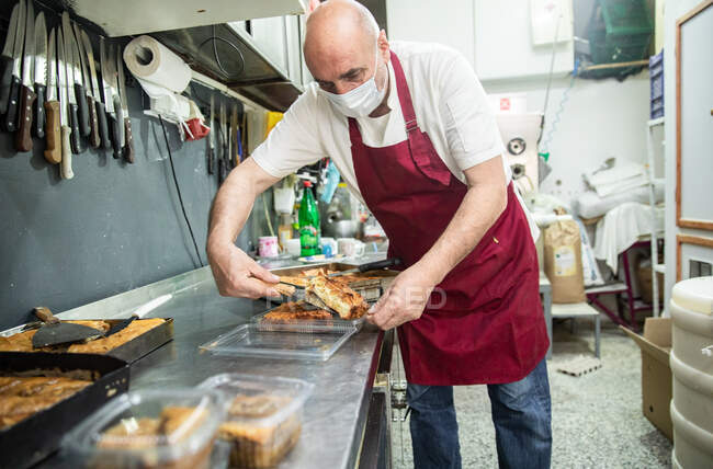 Bäcker trägt Maske und serviert Balkangerichte in Belgrad, Serbien — Stockfoto