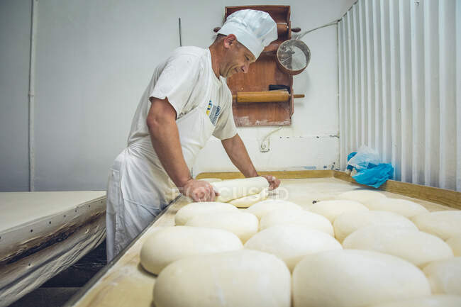 На хлебопекарне в Белграде мужчина раскатал тесто — стоковое фото