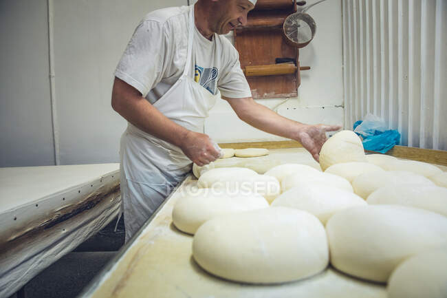 Mann arrangiert Teigrunden in einer Bäckerei in Belgrad, Serbien — Stockfoto