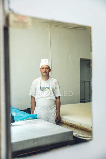 Retrato de um padeiro olhando para um espelho em uma padaria em Belgrado, — Fotografia de Stock