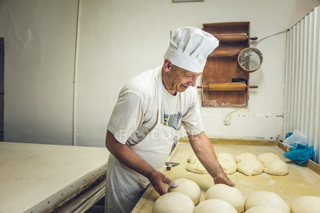 Человек-кузнец устроил тесто на хлебопекарне в Белграде, Сербия — стоковое фото