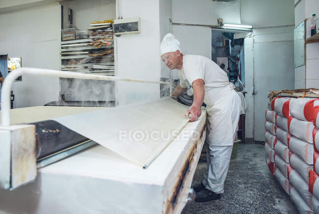 Man Rolling and Steaming Dough em uma padaria em Belgrado, Sérvia — Fotografia de Stock