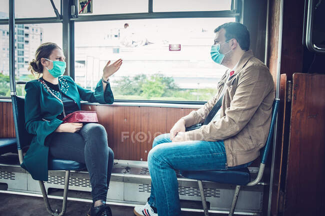 Una mujer y un hombre con máscaras en el tranvía Belgrado, Serbia - foto de stock