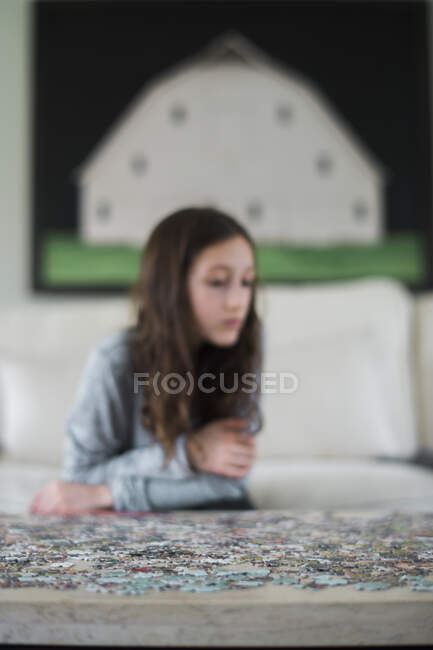 Girl playing with jigsaw puzzle inside — Stock Photo