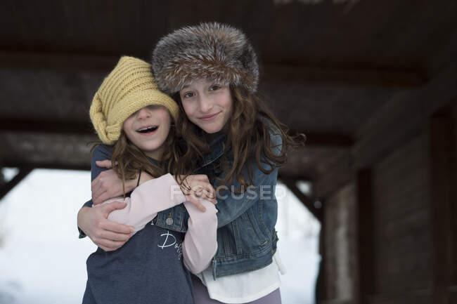 Девушки обнимаются под мостом зимой — стоковое фото