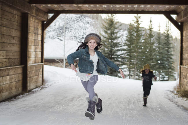 Meninas correndo sob uma ponte nas montanhas — Fotografia de Stock