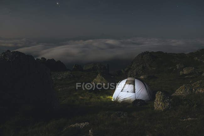 Campamento de montaña por la noche observando nubes desenrollarse, Cantabria, España - foto de stock