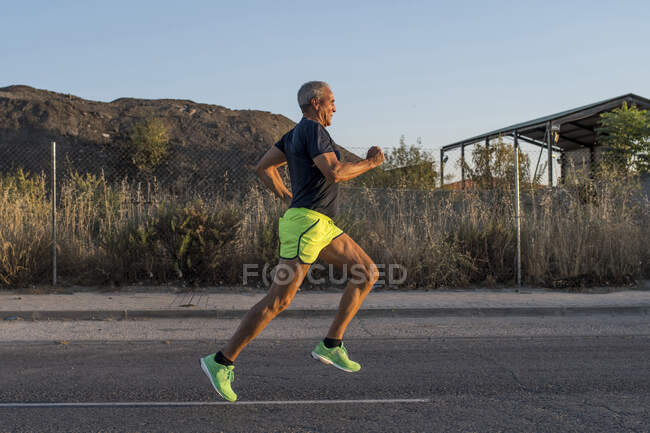 Fit senior man running outdoors — Stock Photo