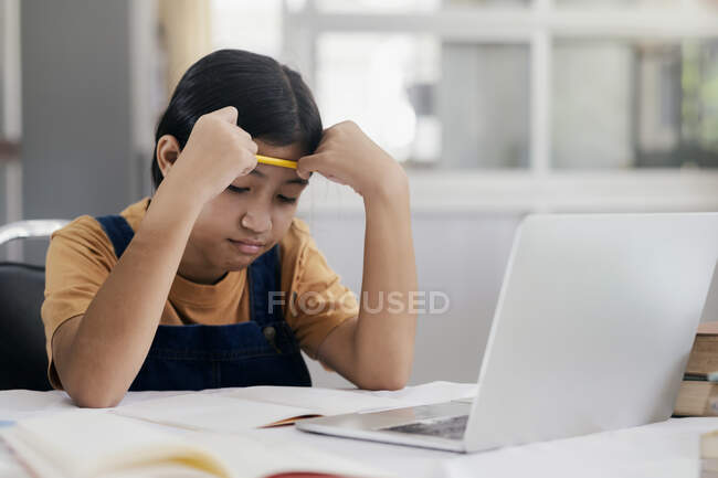 Feliz menina asiática aprendendo online em casa — Fotografia de Stock
