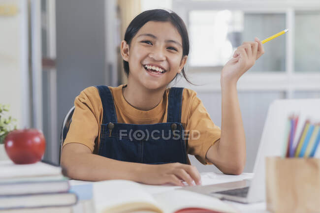 Щаслива азіатська дівчина вчить онлайн вдома — стокове фото