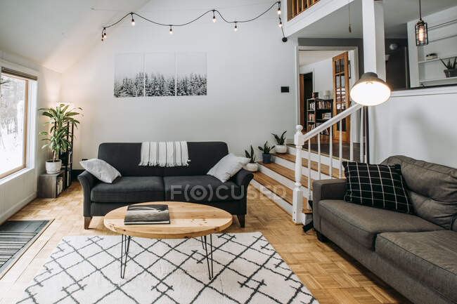 Современный скандинавский интерьер гостиной с диваном и освещением — стоковое фото