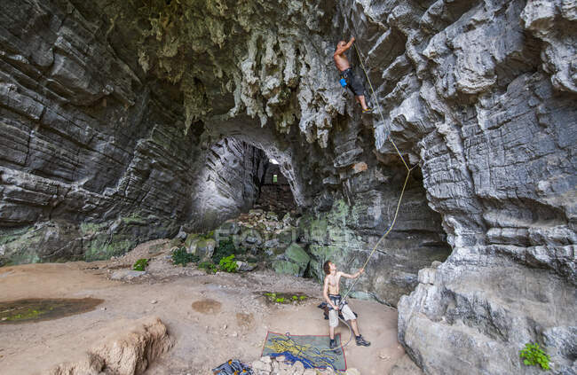 Two men climbing at treasure cave in Yangshuo, China — Stock Photo