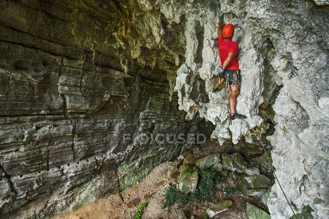 Молодой альпинист карабкается в пещере сокровищ в Яншо, Китай — стоковое фото