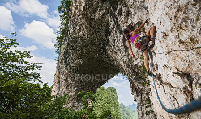 Joven hembra escalando en Moon Hill en Yangshuo, China - foto de stock