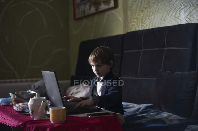 Niño se sienta en una computadora - foto de stock