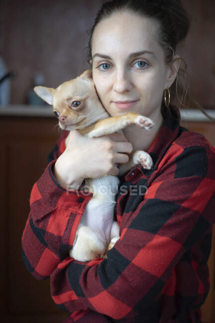 Mulher segurando um cão pequeno — Fotografia de Stock