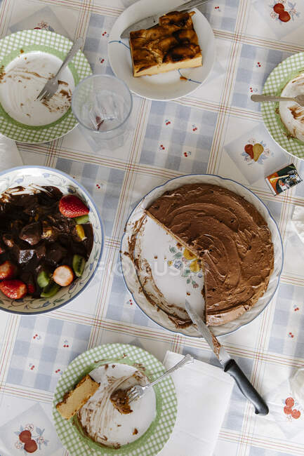 Vista superior do delicioso bolo caseiro colocado na mesa com pratos sujos após a celebração do aniversário — Fotografia de Stock