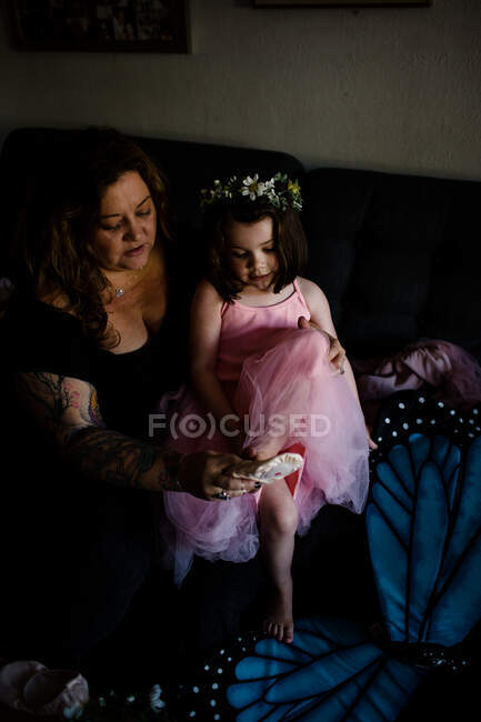 Aunt helping niece put on ballet shoes — Stock Photo