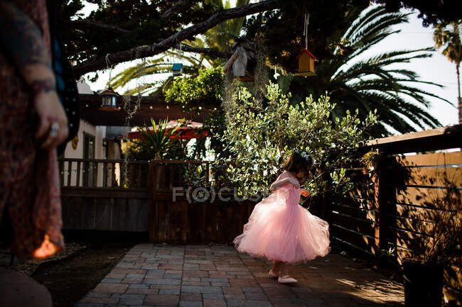 Young girl in tutu dress playing in front yard — Stock Photo