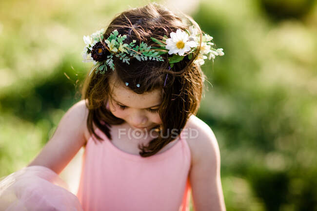 Niedliche kleine Gorl im Blumenkranz lächelt im Freien — Stockfoto
