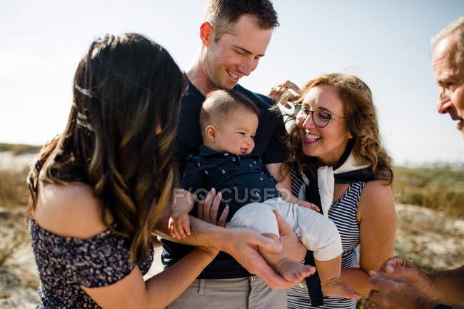 Família sorri como pai segura bebê — Fotografia de Stock
