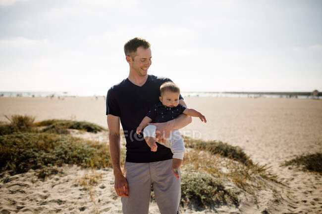 Giovani genitori con bambino sulla spiaggia — Foto stock