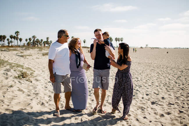 Семья из пяти человек прогуливается по пляжу — стоковое фото