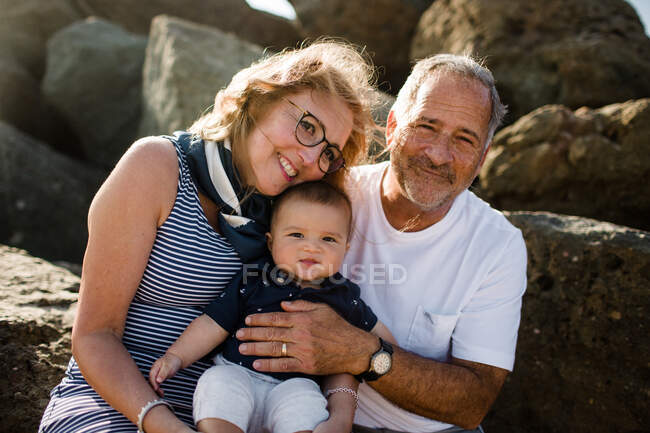 Großeltern halten & umarmen Enkel — Stockfoto