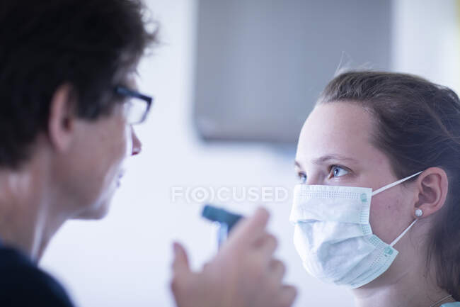 Enfermera y paciente con boquilla y jeringa - foto de stock